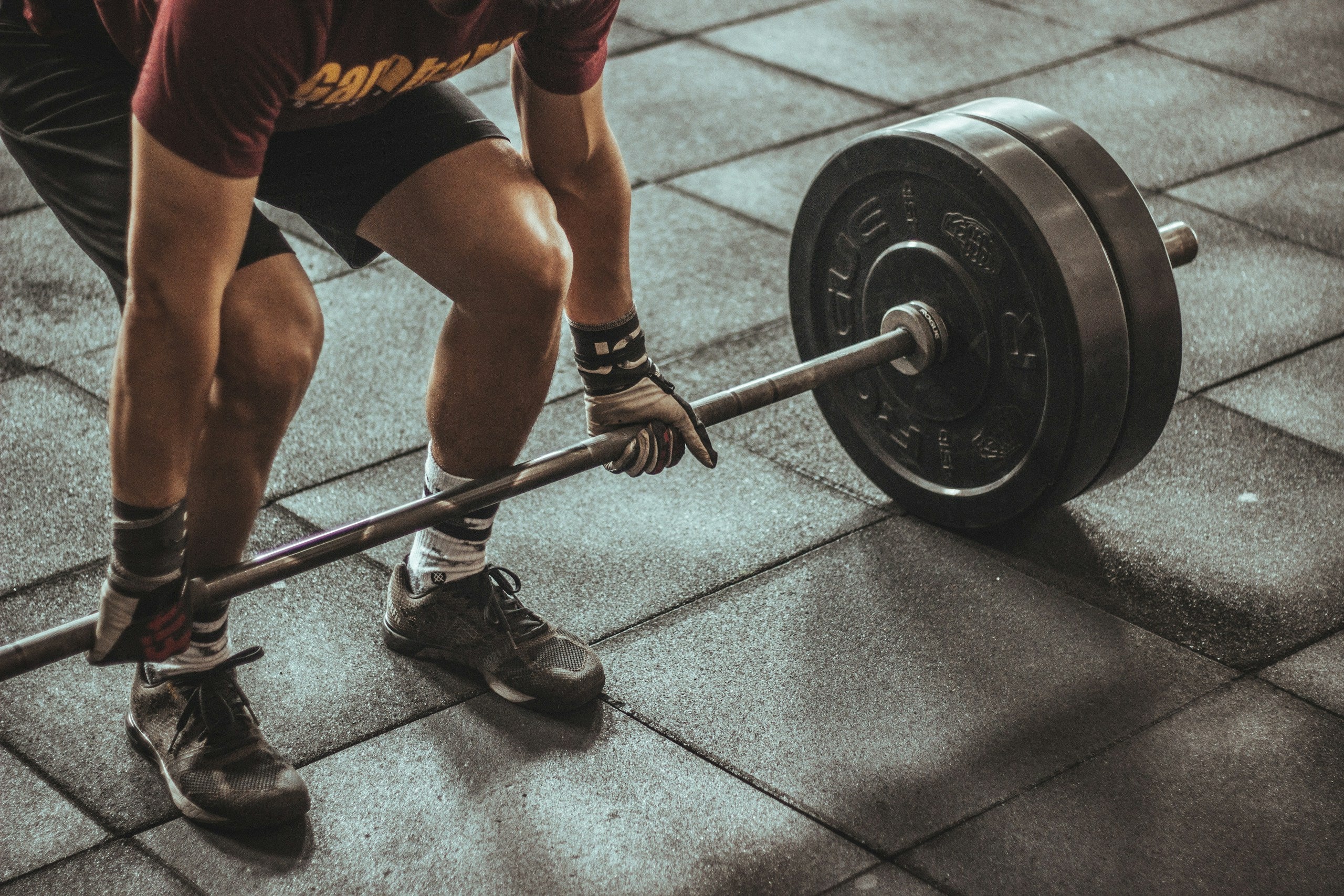 Athlete weightlifting in dark gym - BYS Store hero banner